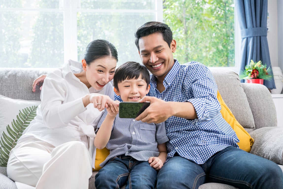 Asian family happy with internet technology on smartphone together